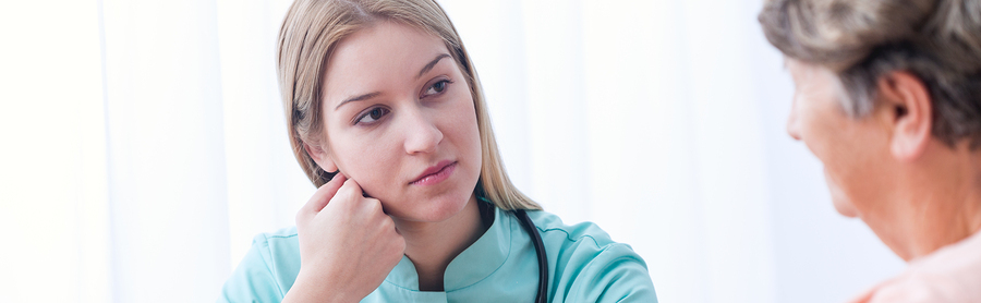 Young pretty nurse listening to her sick patient