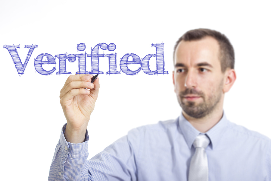 Verified - Young businessman writing blue text on transparent surface